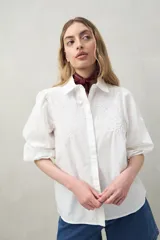 Camisa blanca de mangas 3/4 abullonadas con bordado floral en el frente.