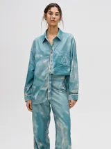 Camisa oversize celeste con estampado tie-dye, bolsillo en el pecho con bordado y terminaciones con ribete en contraste.