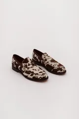 Mocasín confeccionado 100% en cuero con estampado animal print, puntadas artesanales y logo de marca grabado.