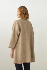 Tapado marrón de largo medio, abierto, con cuello y envivado. Hecho 100% en Uruguay con tela 100% lana fina sin teñir, diseñada exclusivamente por Don Baez.