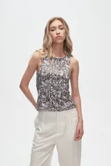 Musculosa blanca sin mangas, ajustada al cuerpo y con cuello redondo.