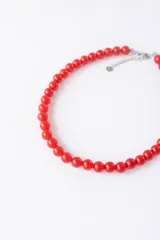 Collar corto de cuentas redondas de vidrio color naranja.