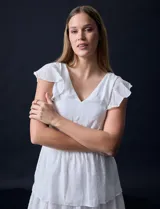 Vestido blanco de gasa con capas de la marca Julia Jordan. Tiene escote en V, mangas cortas con volados, corte en la cintura, abertura central en la espalda con cierre invisible y forro interno a tono.