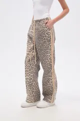 Pantalón de algodón con estampado de leopardo en tonos grises y beige. Diseño recto con cintura elástica ajustable con cordón beige y franja lateral lisa en color beige.