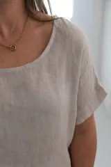 Blusa color crudo de lino, con cuello redondo y mangas cortas.