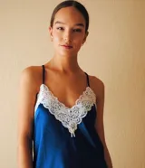 Camisón azul de satén con breteles finos y escote en V con detalle de puntilla blanca.