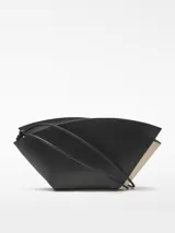 Bolso de hombro de cuero color beige y negro, con forma geométrica asimétrica y asa fina negra.