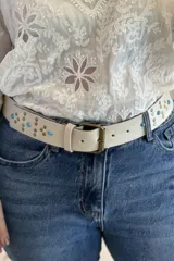 Cinturón marrón de cuero vacuno con hebilla metálica y apliques de tachas y turquesas.