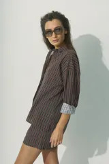 Camisa marrón a rayas verticales negras y rojas, de corte relaxed, con cuello clásico y botones al tono.