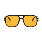Lentes de sol unisex con montura cuadrada negra y cristales amarillos.