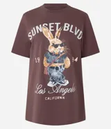 Remera marrón de algodón con cuello redondo y mangas cortas. Estampa frontal de un conejo con gafas de sol y texto "Sunset Blvd. Los Angeles California".
