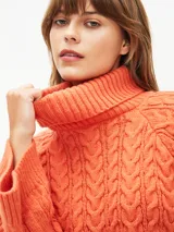 Sweater tejido color naranja oscuro, con cuello alto y mangas largas acampanadas.