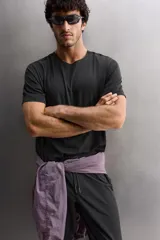 Camiseta deportiva negra de tejido técnico ligero con perforaciones, cuello redondo y manga corta.