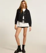 Campera boxy de jeans azul, con cuello clásico, cierre frontal con botones, bolsillos con solapas abotonadas en el pecho y recortes.