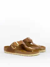 Sandalias Birkenstock modelo Gizeh con hebilla grande, color marrón cognac. Fabricadas en Birko-Flor, material sintético suave y resistente. Plantilla anatómica de corcho y látex forrada en cuero liso. Suela de EVA ligera y flexible.