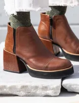 Botas cortas negras con textura de piel de serpiente y detalles en charol.