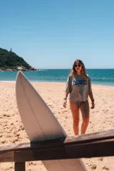 Remerón cropped gris con estampado de motivos playeros en azul y texto "Glassy Waves".