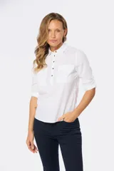 Camisa blanca de lino con mangas largas, cuello clásico, medio abotonada y bolsillo en el pecho. Tiene presilla en la manga para mayor comodidad.