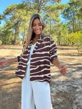 Camisaco de seda con estampado animal print de rayas horizontales en tonos marrón oscuro y beige claro. Tiene cuello solapa y botones frontales.