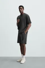 Bermuda negra de corte relaxed fit, con cintura elástica ajustable con cordón, bolsillos frontales y bolsillo trasero de parche.