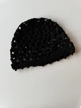 Casquete tejido a crochet en hilo metalizado color gris plata, con diseño calado.