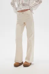 Pantalón jean negro de tiro alto, corte flare y detalle de tachas plateadas en los laterales.