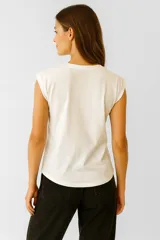 Remera color crema de algodón con estampado de un velero y la frase "Rough Waters Make The Best Sailors" en azul.