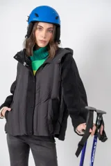 Campera negra con mangas de lana y cuerpo de nylon acolchado, con capucha y cierre frontal con botones a presión.