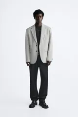 Blazer straight fit color gris claro confeccionado en tejido con viscosa. Tiene cuello con solapas de muesca, manga larga acabada en puño con botón, bolsillo de vivo en pecho, bolsillos de plastrón en cadera y bajo con aberturas en espalda. Cierre frontal de botonadura.