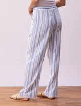 Pantalón de lino a rayas verticales color beige y blanco, con pretina ancha elastizada, lazo de ajuste y bolsillos inclinados.