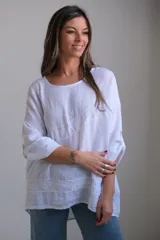 Blusa blanca de lino con mangas 3/4 y detalle de bordado calado en el frente y ruedo.