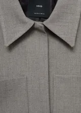 Chaqueta corta gris con cuello camisero, cierre frontal con botones ocultos, dos bolsillos de parche delanteros y forro interior.
