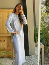 Vestido largo de tejido de punto gris jaspeado, manga larga y cuello redondo. El calce es holgado y relajado.