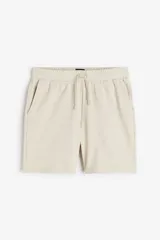 Short color beige en felpa liviana de mezcla de algodón. Modelo con cintura elástica y cordón para ajustar, bolsillos al bies y un bolsillo abierto atrás. Corte estándar para una silueta clásica y cómoda.