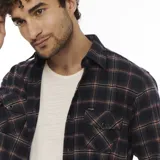 Camisa Wrangler de franela a cuadros en tonos azul marino, rojo y blanco. Tiene dos bolsillos con solapa abotonada en el pecho y cierre frontal con botones.