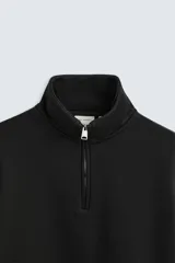 Sudadera negra de algodón con cuello alto y cierre de cremallera frontal. Corte relaxed fit, manga larga y terminaciones en rib.