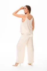 Pantalón de vestir color beige, de corte palazzo y tiro alto, con bolsillos laterales y pinzas frontales.