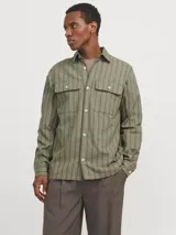 Sobrecamisa de manga larga color verde oliva con rayas verticales finas en tono más claro. Tiene cuello clásico, cierre con botones, dos bolsillos en el pecho con cierre de botón y puños abotonados. Corte recto y cómodo. Confeccionada en tejido de sarga de algodón y lino.