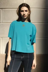 Remera negra de algodón con corte cuadrado, cuello redondo y logo bordado en color naranja.