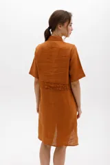 Vestido camisero a rayas con cuello y cartera en tono lima claro, volados frontales y laterales. De calce relajado y mangas cortas. Fabricado en Uruguay.