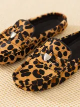 Mocasín de cuero vacuno con estampado animal print, detalle metálico en forma de corazón y suela de goma.