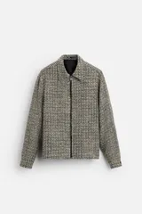 Sobrecamisa de tweed multicolor con cuello solapa, cierre frontal con cremallera, bolsillos laterales y puños abotonados.