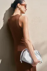Vestido tobillero marrón sin mangas en punto tupido, con escote en V, sección drapeada con nudo decorativo y detalles cut-out adelante, y falda con leve vuelo.