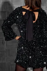 Vestido corto negro con lentejuelas, de mangas largas y escote redondo.
