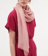 Pañuelo liso color rosa claro, rectangular, con terminaciones desflecadas.