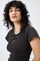 Body negro de punto canalé con mangas cortas, confeccionado en tejido suave y elástico que combina algodón, poliéster y elastano.