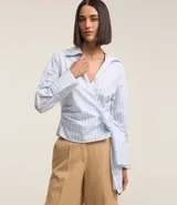 Blusa celeste a rayas verticales, de tricolina, con escote en pico cruzado, lazo lateral, mangas largas y cuello solapa.