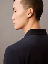 Chomba de piqué de algodón color azul marino, corte regular, con cuello clásico y tapeta de dos botones. Logo de la marca bordado en el pecho.