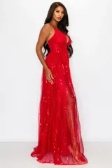 Vestido largo de fiesta color rojo con escote en V, breteles finos y falda con abertura lateral. El vestido está confeccionado en tul con lentejuelas verticales.