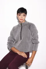 Sweater lila de punto con cuello alto y cierre de cremallera metálica.